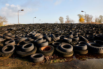 Stack of abandoned truck on field against sky