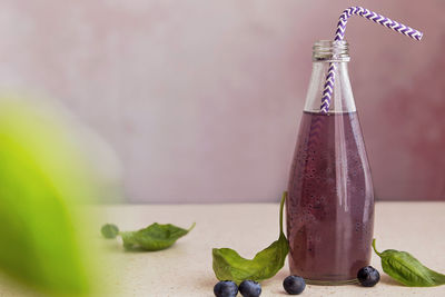 Soft organic purple cocktail bottle with blueberries, seeds, basil extract, leaves. 