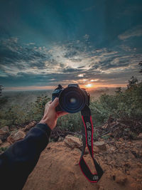 Man photographing camera against sky