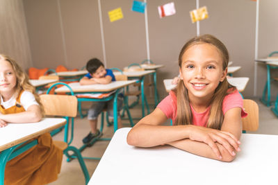 Portrait of smiling girl sitting on table