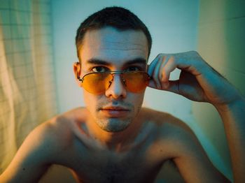 Close-up portrait of shirtless man in sunglasses
