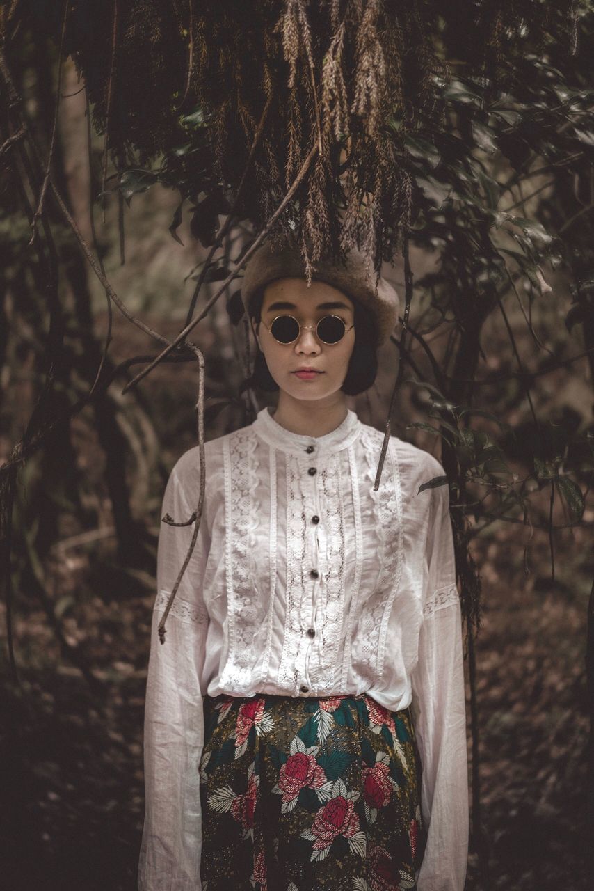 real people, one person, plant, portrait, tree, leisure activity, looking at camera, fashion, young adult, front view, lifestyles, forest, land, standing, focus on foreground, women, casual clothing, waist up, young women, hairstyle, beautiful woman, outdoors, woodland