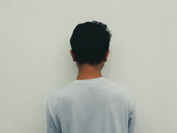 Rear view of man standing against white background