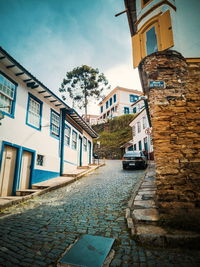 Street amidst buildings in city against sky