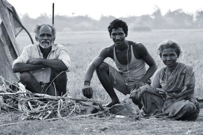 Full length portrait of family sitting on field