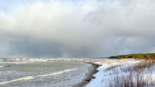 Frozen sea shore in winter with snowy dunes. atmospheric empty winter sea and beach landscape.