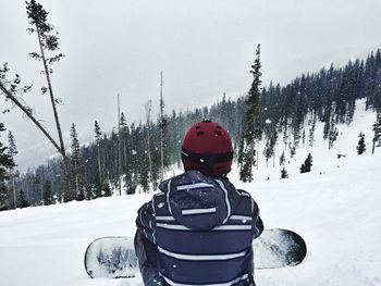 View of snowboarder sitting in snow