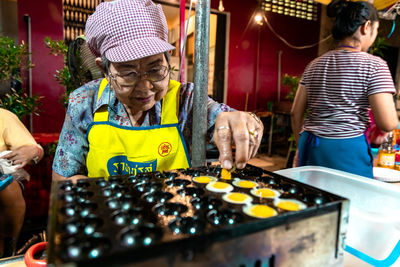 Rear view of people holding food at market