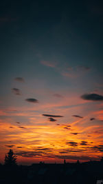 Silhouette trees on field against romantic sky at sunset