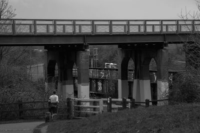 Rear view of woman walking by bridge