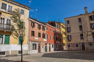 Residential buildings in city against clear blue sky