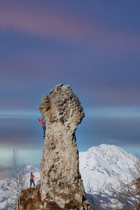 Rock formation on snowcapped mountain against sky