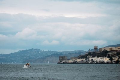 Scenic view of river and mountains against cloudy sky