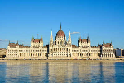 View of buildings against clear blue sky