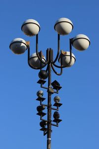 Low angle view of lamp post against clear blue sky