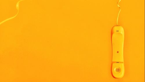 Close-up of phone on yellow background