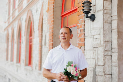 A man groom with a bouquet of flowers	