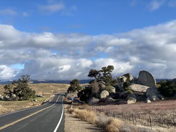 Empty road along landscape and against sky