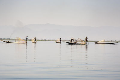 Fisherman fishing on lake in foggy weather