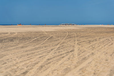 Scenic view of beach against clear blue sky