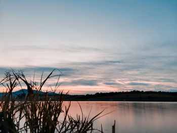 Scenic view of lake against sky during sunset