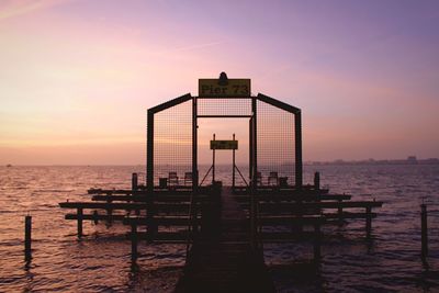 Pier on sea at sunset