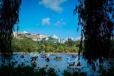 Boats moored on shore against blue sky