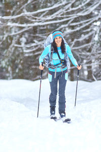 Portrait of woman skiing on snow covered field