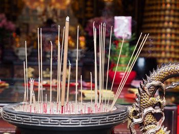Close-up of candles in temple against building