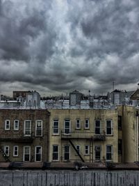 Low angle view of buildings against cloudy sky