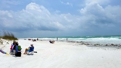 People at beach against sky