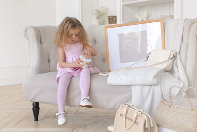 Cute girl playing with jar on elegant sofa