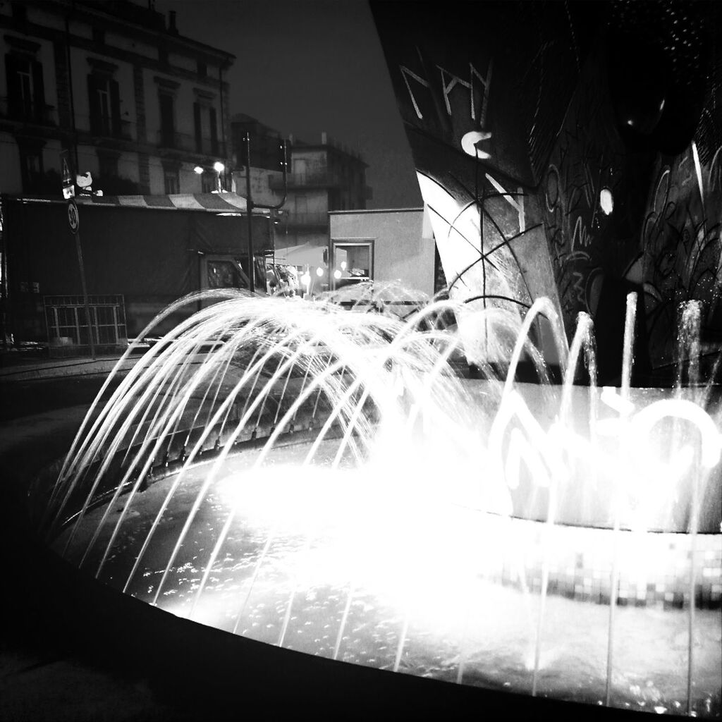 building exterior, architecture, built structure, motion, night, long exposure, fountain, illuminated, spraying, blurred motion, building, water, outdoors, glowing, no people, city, reflection, light - natural phenomenon, fire - natural phenomenon, house