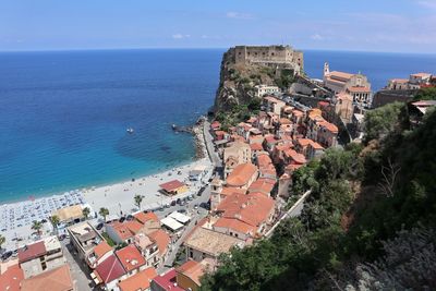 High angle view of townscape by sea against sky