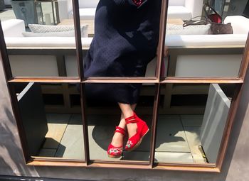 Low section of woman standing on chair in store