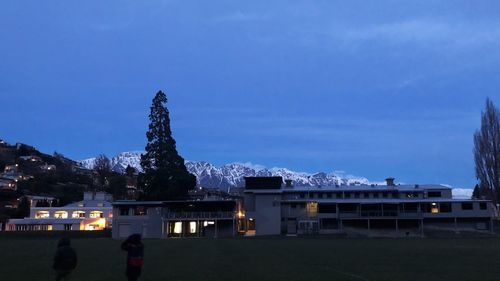 Illuminated building against blue sky at dusk