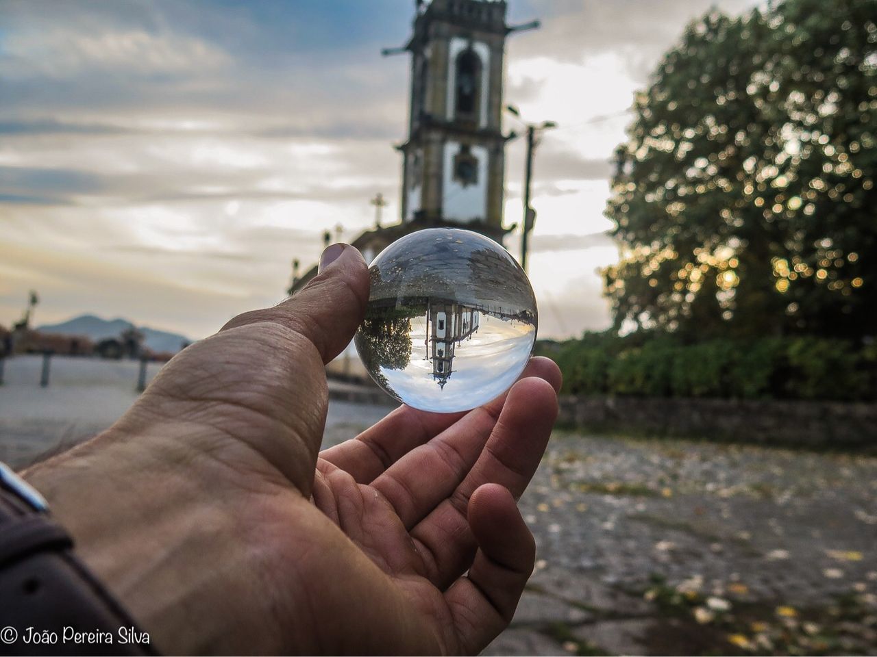 human hand, hand, holding, human body part, one person, finger, human finger, nature, sky, crystal ball, real people, unrecognizable person, focus on foreground, sphere, personal perspective, body part, transparent, day, cloud - sky, built structure, outdoors