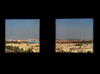 Cityscape against sky seen through window