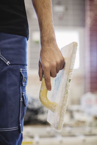 Midsection of carpentry student holding hand float at workshop