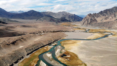 Aerial view of mountain range against cloudy sky