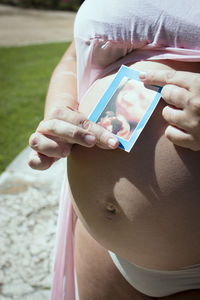 Midsection of woman holding umbrella