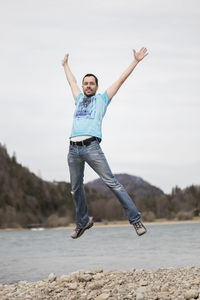 Full length of woman jumping against sky