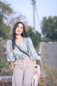 Beautiful young woman looking away while standing outdoors