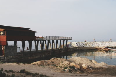 Bridge over sea against clear sky