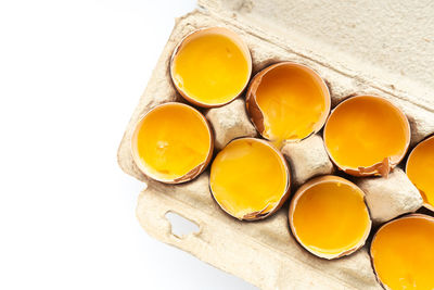 High angle view of yellow eggs against white background