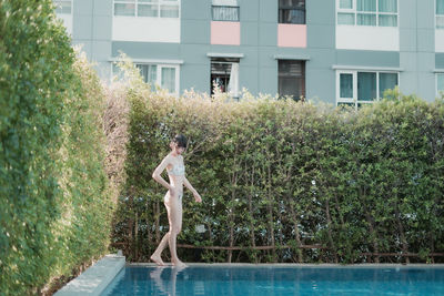 Woman standing by swimming pool