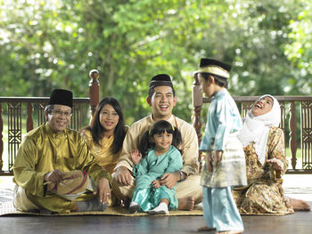 Family sitting in gazebo during traditional festival