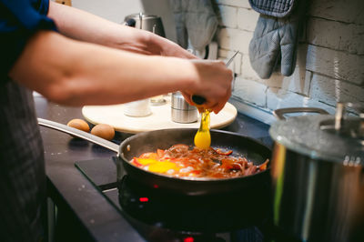 Midsection of woman preparing food in kitchen