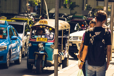 Rear view of men on street in city