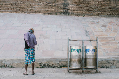 Rear view of man standing against wall